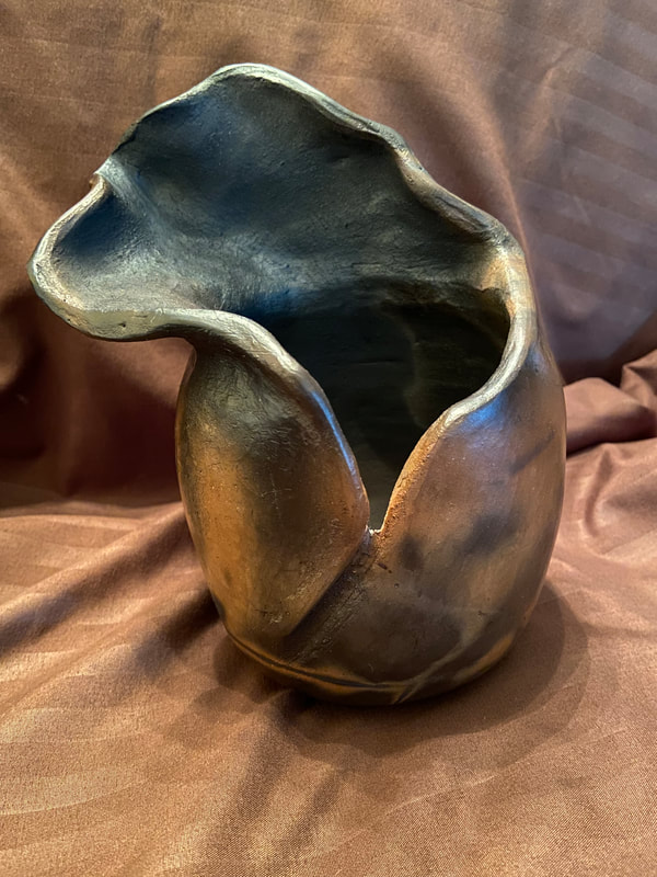 The top half of this open vessel has the look and feel of the wind blowing it away...to who knows where? Saggar fired to achieve a variety of smoke, gray, and black colorings.