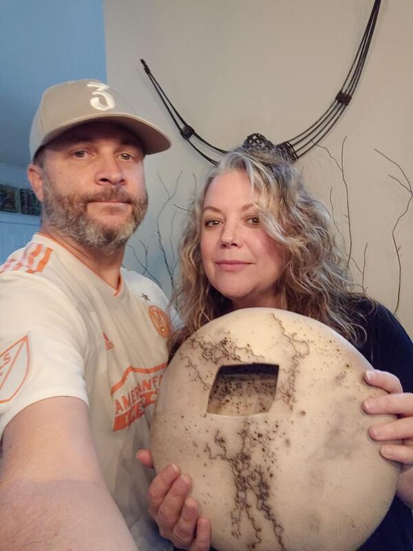 White clay pot, raku fired using horse hair. Couple is holding their new pot.