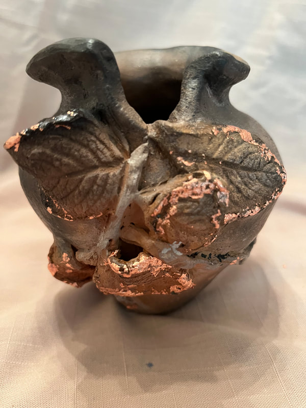 Small vase with leaves cascading down the front. Burnished, pit fired. 