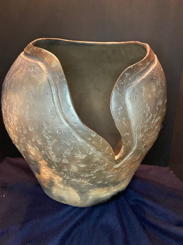 Large pot with V-shaped opening at the front. Textured and burnished, then saggar fired to achieve varying colors.